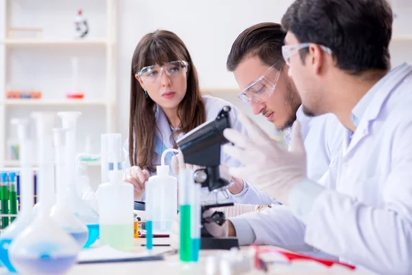 Equipe de químicos que trabalham no laboratório — Fotografia de Stock