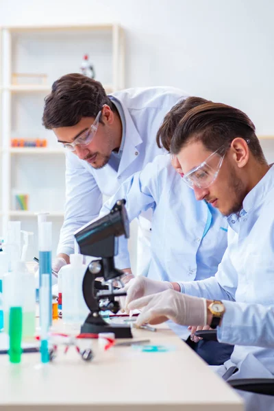 Laboratuvarda çalışan kimyagerler.