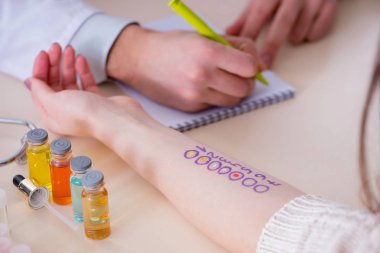 Hastanedeki hastanın alerji reaksiyonunu test eden doktor.