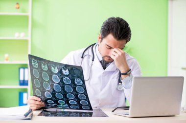 Doktor radyoloji uzmanı hastanede röntgen taramasına bakıyor.