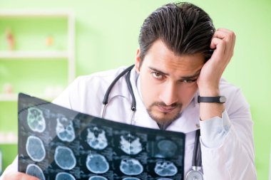 Doktor radyoloji uzmanı hastanede röntgen taramasına bakıyor.