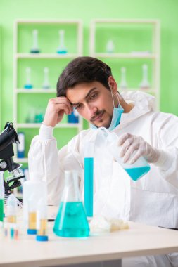 Laboratuvarda yeni bir deney üzerinde çalışan kimyager.