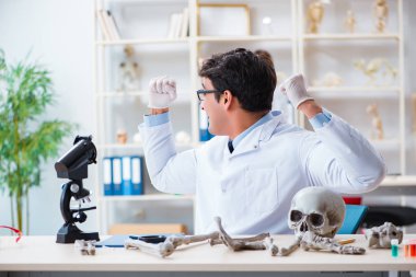 Profesör laboratuvarda insan iskeletini inceliyor.