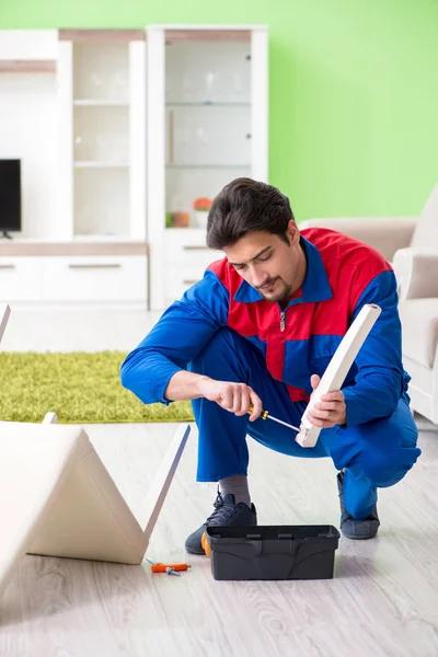 Müteahhit evde kırık sandalyeyi tamir ediyor.