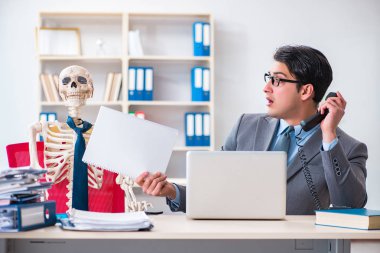 İskeletle çalışan bir iş adamı.