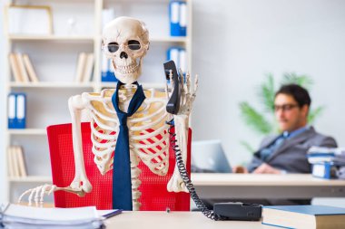 İskeletle çalışan bir iş adamı.