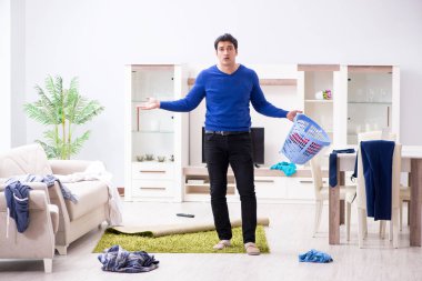 Genç adam çamaşırhane için kirli çamaşır topluyor.