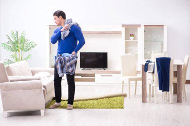 Genç adam çamaşırhane için kirli çamaşır topluyor.