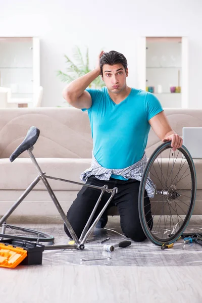 Młodzieniec naprawiający rower w domu — Zdjęcie stockowe
