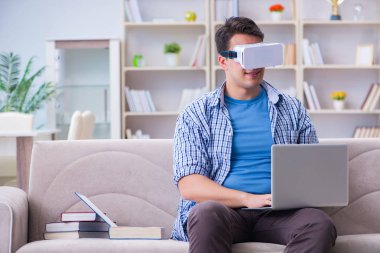 Evde sanal gerçeklik gözlükleriyle serbest çalışan bir öğrenci.
