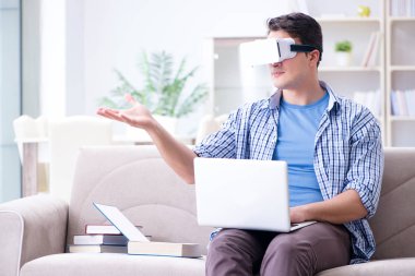 Evde sanal gerçeklik gözlükleriyle serbest çalışan bir öğrenci.