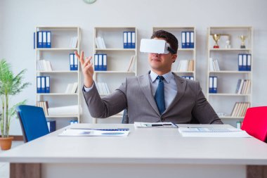 Ofiste sanal gerçeklik gözlüklü bir iş adamı var.