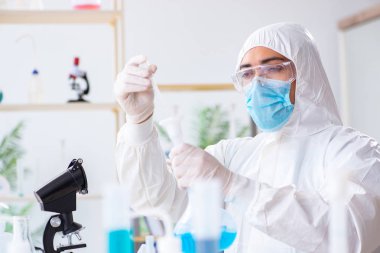Laboratuvarda kimyasallar üzerinde çalışan genç bir kimyager.