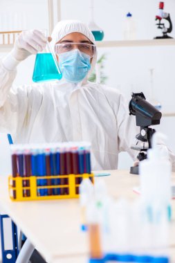 Laboratuvarda kimyasallar üzerinde çalışan genç bir kimyager.