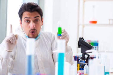 Laboratuvarda kimyasallar üzerinde çalışan genç bir kimyager.
