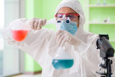 Laboratuvarda yeni bir deney üzerinde çalışan kimyager.