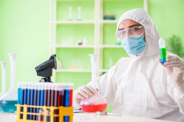 Laboratuvarda yeni bir deney üzerinde çalışan kimyager.