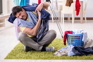 Yakışıklı koca evde çamaşır yıkıyor.