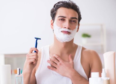 Genç yakışıklı adam sabah erkenden tıraş oluyor.