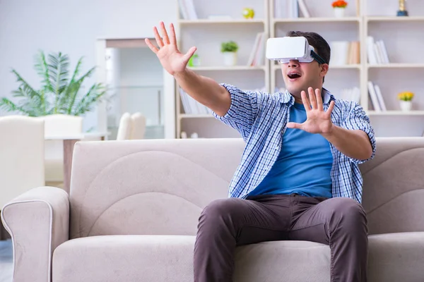 Homem com óculos de realidade virtual jogando em casa — Fotografia de Stock