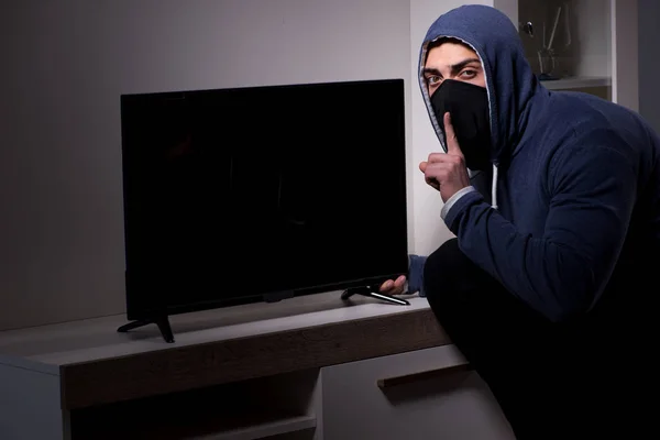 Бурґларський злодій краде телевізор з багатоквартирного будинку — стокове фото