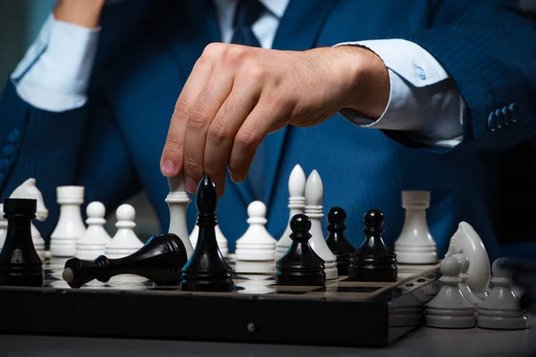 Businessman playing chess in strategy concept