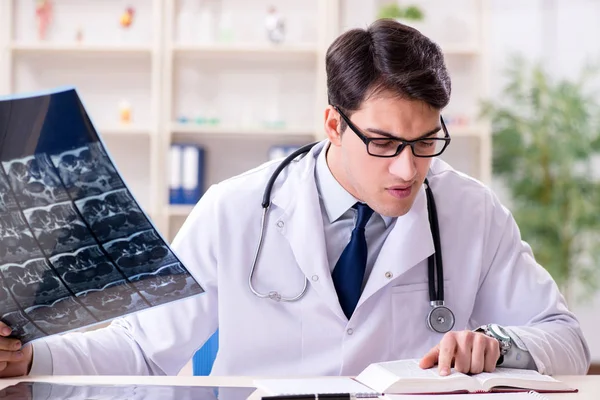 Jeune médecin regardant des images radiographiques à la clinique — Photo