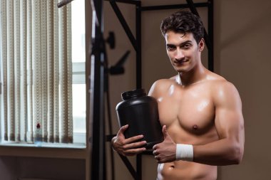 Spor salonunda besin takviyesi olan bir adam.