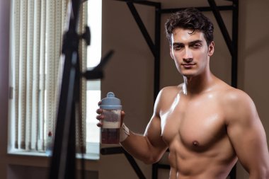 Spor salonunda besin takviyesi olan bir adam.