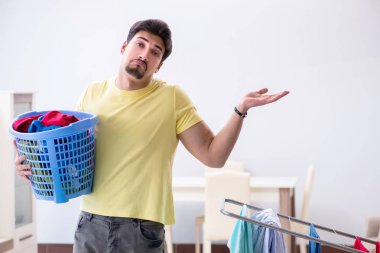 Yakışıklı koca evde çamaşır yıkıyor.