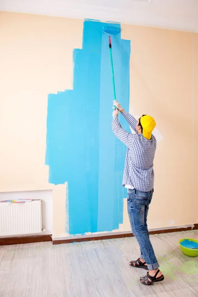 Pittore uomo pittura il muro a casa — Foto Stock