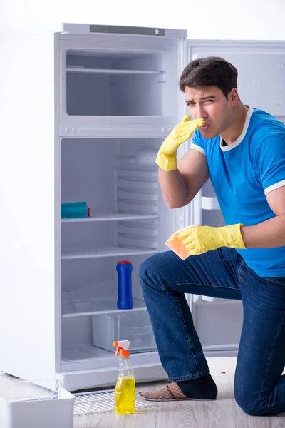 Mann putzt Kühlschrank im Hygienekonzept — Stockfoto