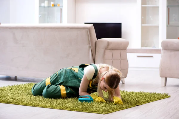 Professional female cleaner cleaning carpet