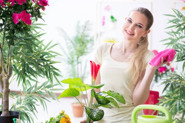 Молода жінка поливає рослини в саду — стокове фото