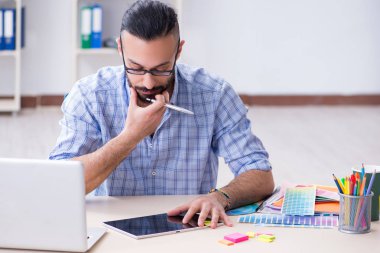 Genç tasarımcı stüdyosunda yeni bir proje üzerinde çalışıyor.