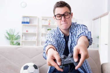 Genç adam evde bilgisayar oyunu oynuyor.