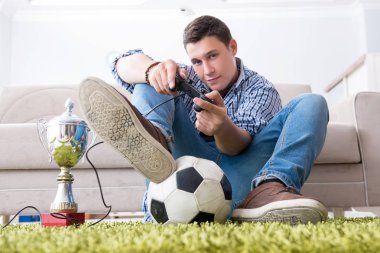 Genç adam evde bilgisayar oyunu oynuyor.