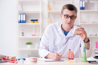 Tıp laboratuarına diş implantı yerleştiren dişçi.