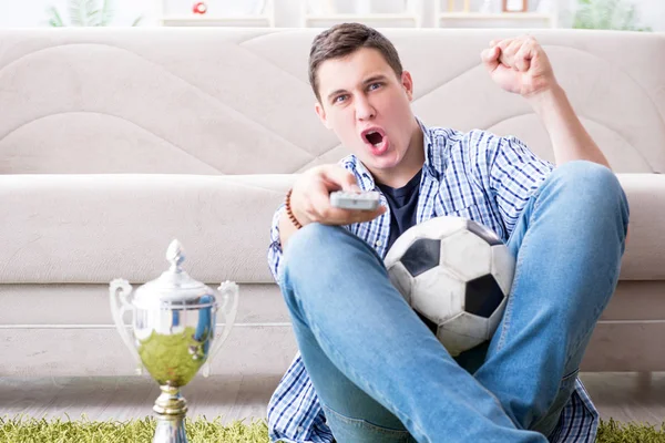 Jovem estudante assistindo futebol em casa — Fotografia de Stock