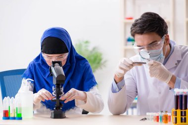 Laboratuvarda çalışan iki kimyager.