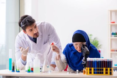 Laboratuvarda çalışan iki kimyager.