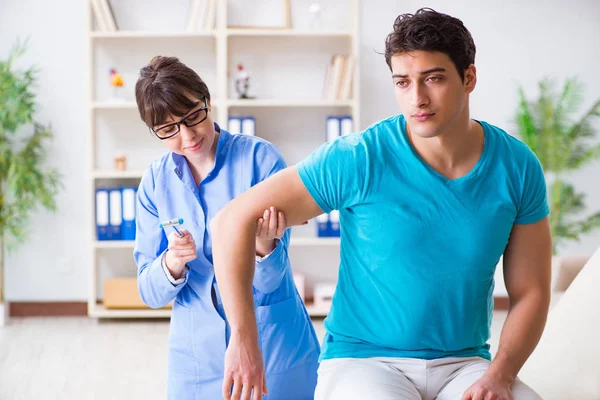 Médico verificando reflexos nervosos com martelo — Fotografia de Stock