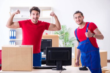 İki müteahhit personel kişisel eşyalarını taşıyor.