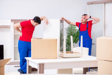 İki müteahhit personel kişisel eşyalarını taşıyor.