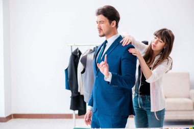 Profesyonel terzi resmi kıyafet için ölçü alıyor.