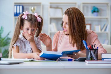 Anne, kızına ödevlerinde yardım ediyor.