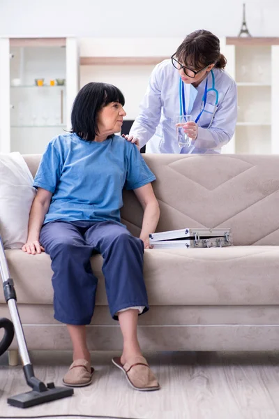 Mladý lékař návštěva staré dospělé ženy pro check-up — Stock fotografie