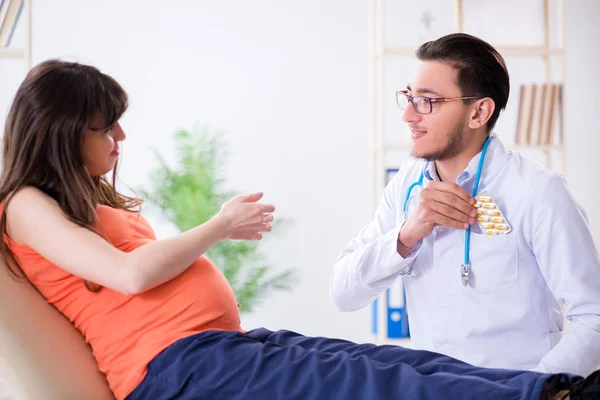 Terhes nő a férjével az orvosnál a klinikán. — Stock Fotó