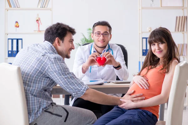 Mulher grávida com o marido visitando o médico na clínica — Fotografia de Stock