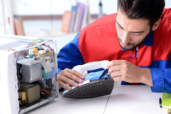 Man repairman repairing iron at service center